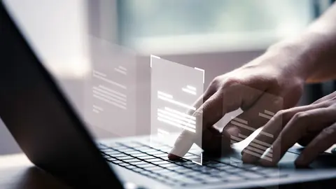 Hand using laptop computer with virtual screen and document for online approve paperless quality assurance and ERP management concept.